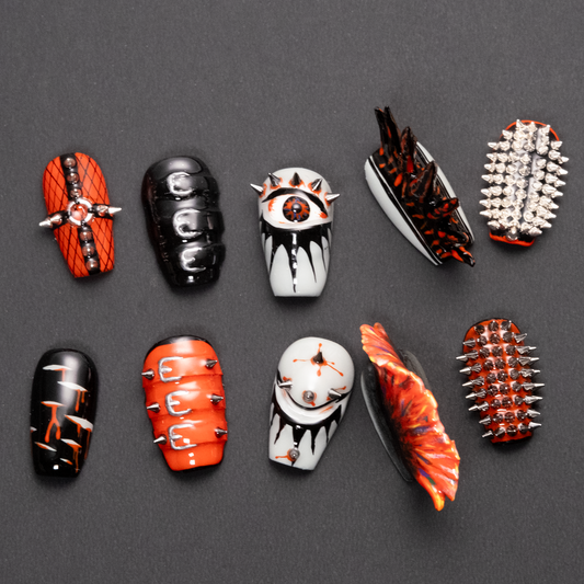 A set of ten punk-inspired press-on nails featuring bold designs with spikes, studs, buckles, and dripping effects in red, black, and gray tones.