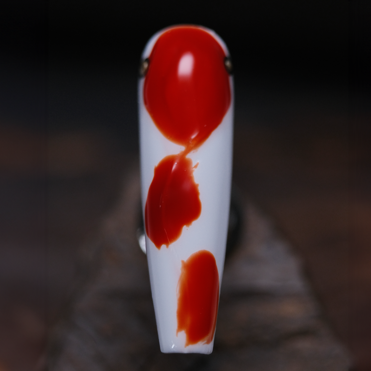 A close-up of a koi-inspired press-on nail with a glossy finish, featuring vibrant red and white patterns, capturing the essence of good luck.