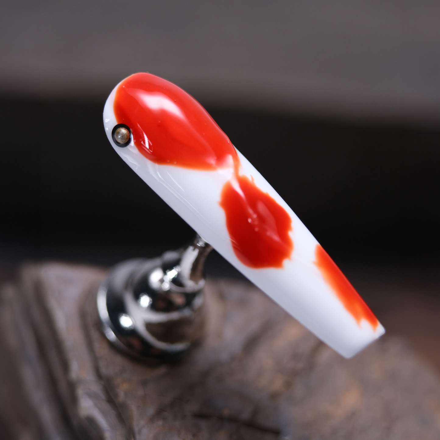 A close-up of a koi-inspired press-on nail with a red and white design, featuring a smooth glossy finish that captures the elegance of the koi fish.