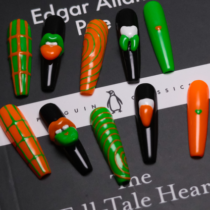 A set of Gothic-inspired press-on nails with bold green and orange designs, featuring 3D lips, teeth, and intricate patterns for a striking, edgy style.