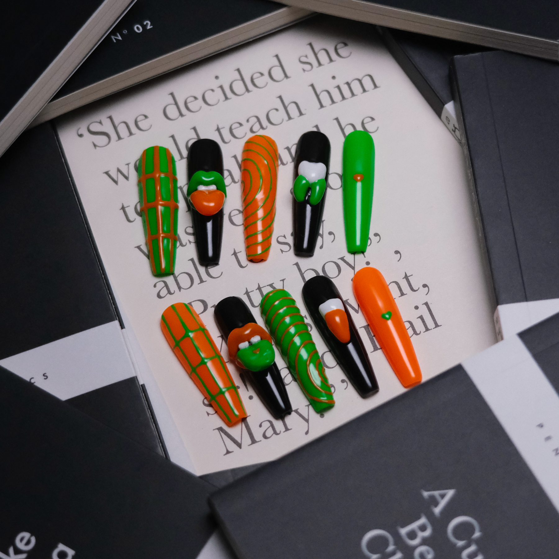 A set of Gothic-inspired press-on nails with bold green and orange designs, featuring striking 3D lip and tooth accents, exuding edgy elegance.